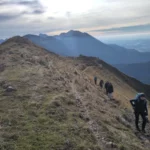 Hiking trail with five people overlooking mountains and valley