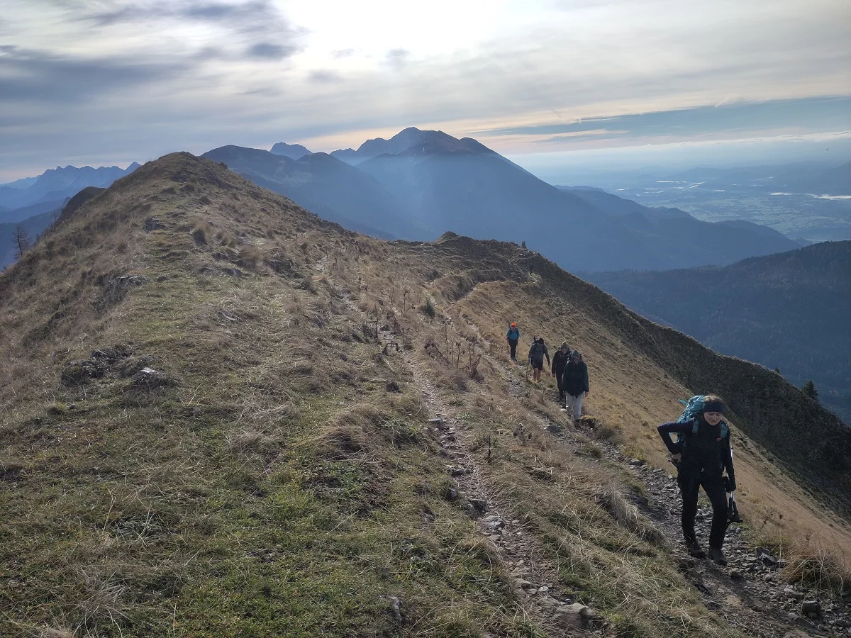 Wanderweg mit fünf Menschen mit Blick auf Berge und Tal